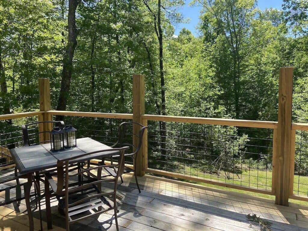 Wooded deck and outdoor dining area at Rustic Retreat cabin