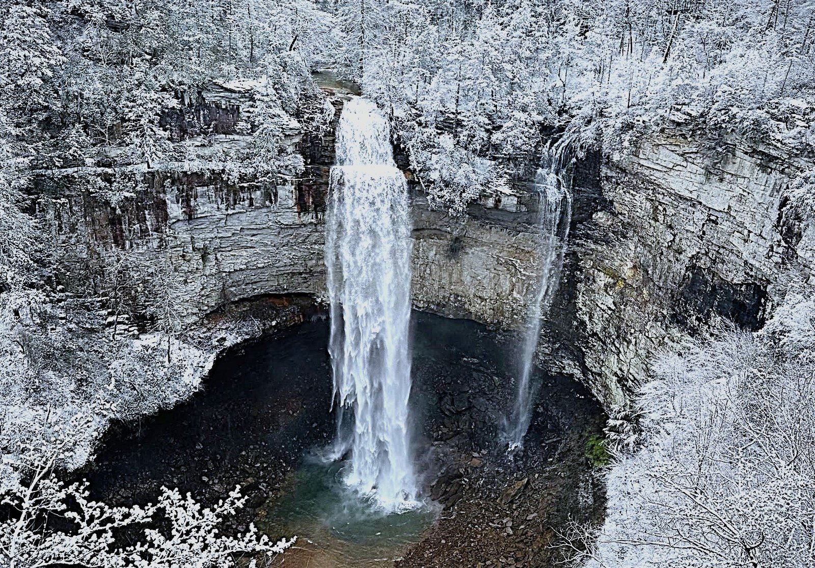 Fall Creek Falls and Coon Creek Falls surrounded by snow-covered trees